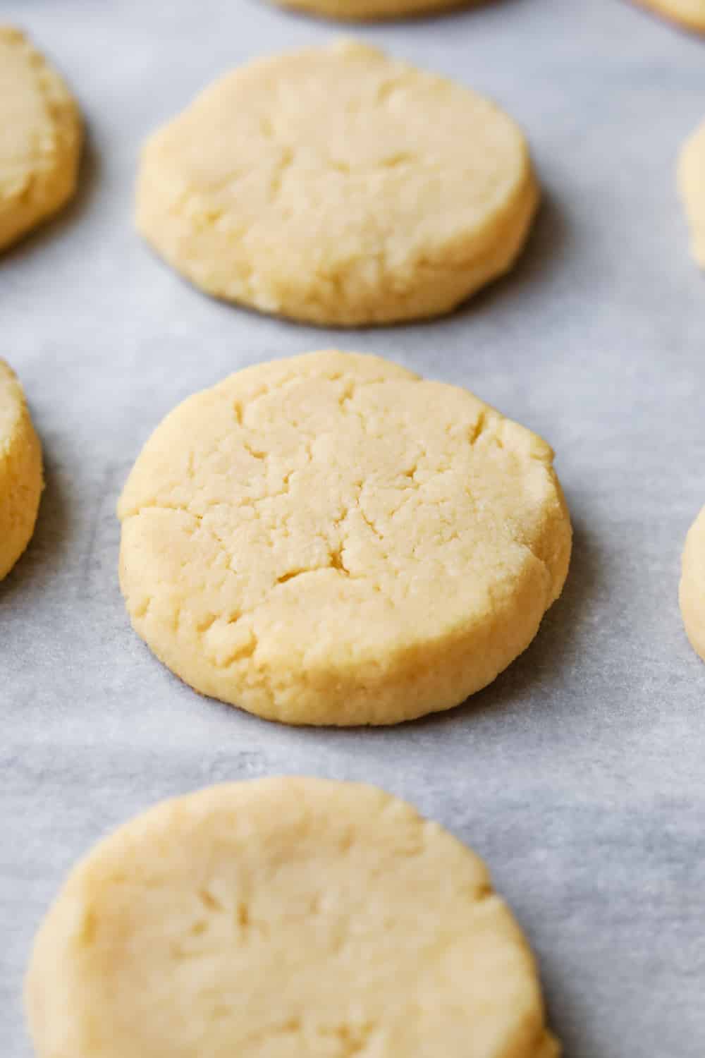 Lemon cookies set on a sheet of parchment paper.