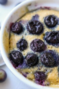 Half of a blueberry muffin in a mug