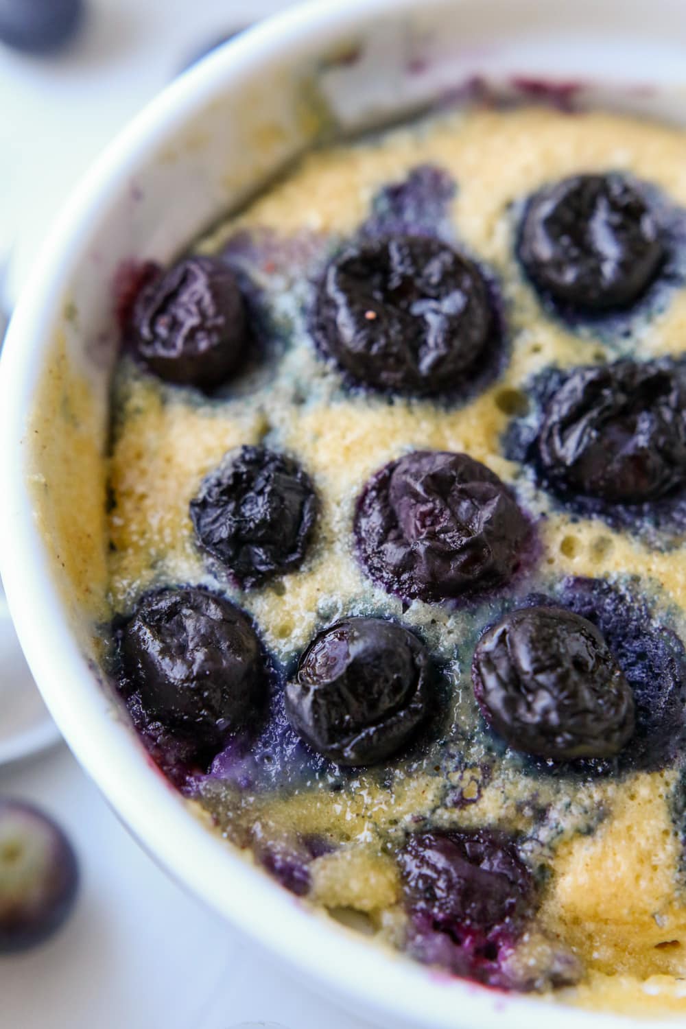 Half of a blueberry muffin in a mug