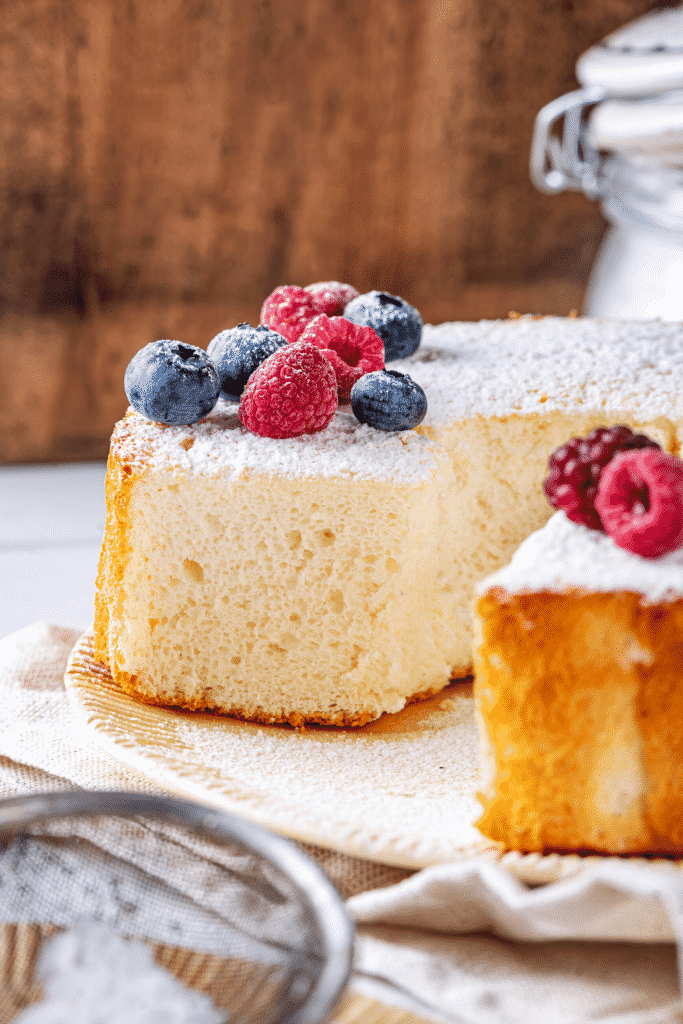 An angel food cake on a plate with two slices taken out of the front of the cake