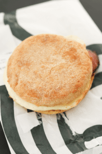 Starbucks egg white turkey bacon and cheddar cheese breakfast sandwich and a Starbucks bag.