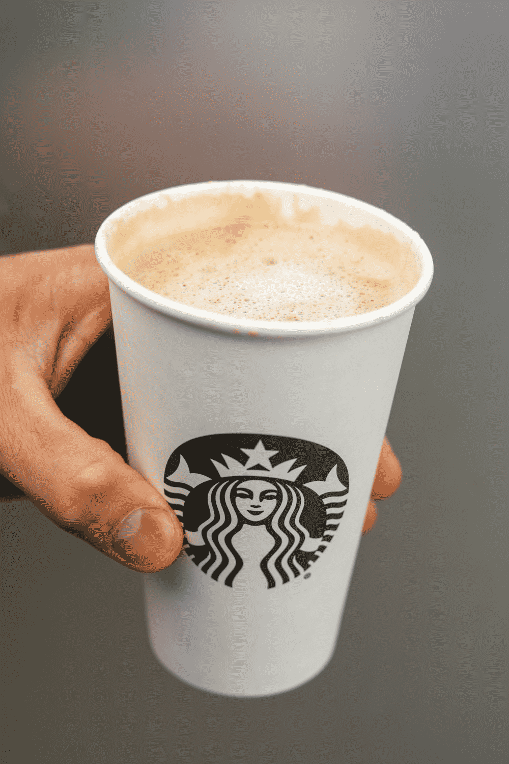 A hand holding a cup of Starbucks keto blonde vanilla latte.