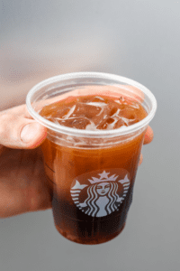 A hand holding a cup of Starbucks keto ice shaken espresso.