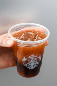 A hand holding a cup of A hand holding a Starbucks keto ice shaken espresso.