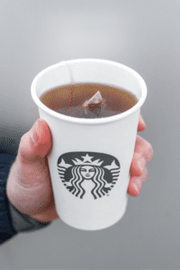 A hand holding a cup of Starbucks in Jade citrus mint tea.