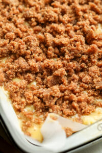 A cake tray filled with cake batter and a cinnamon crumble topping.