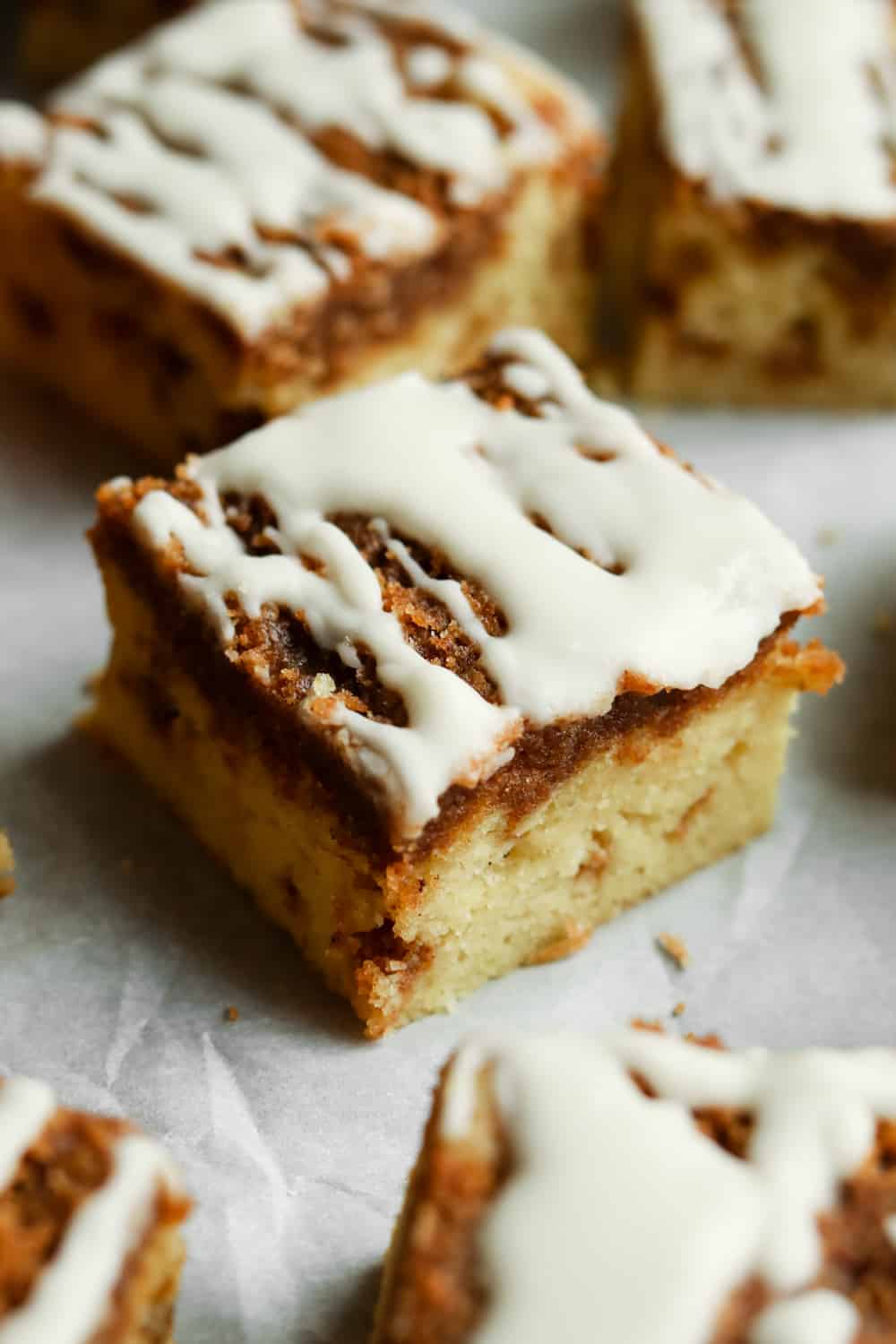 A piece of coffee cake on a baking sheet lined with white parts in paper.