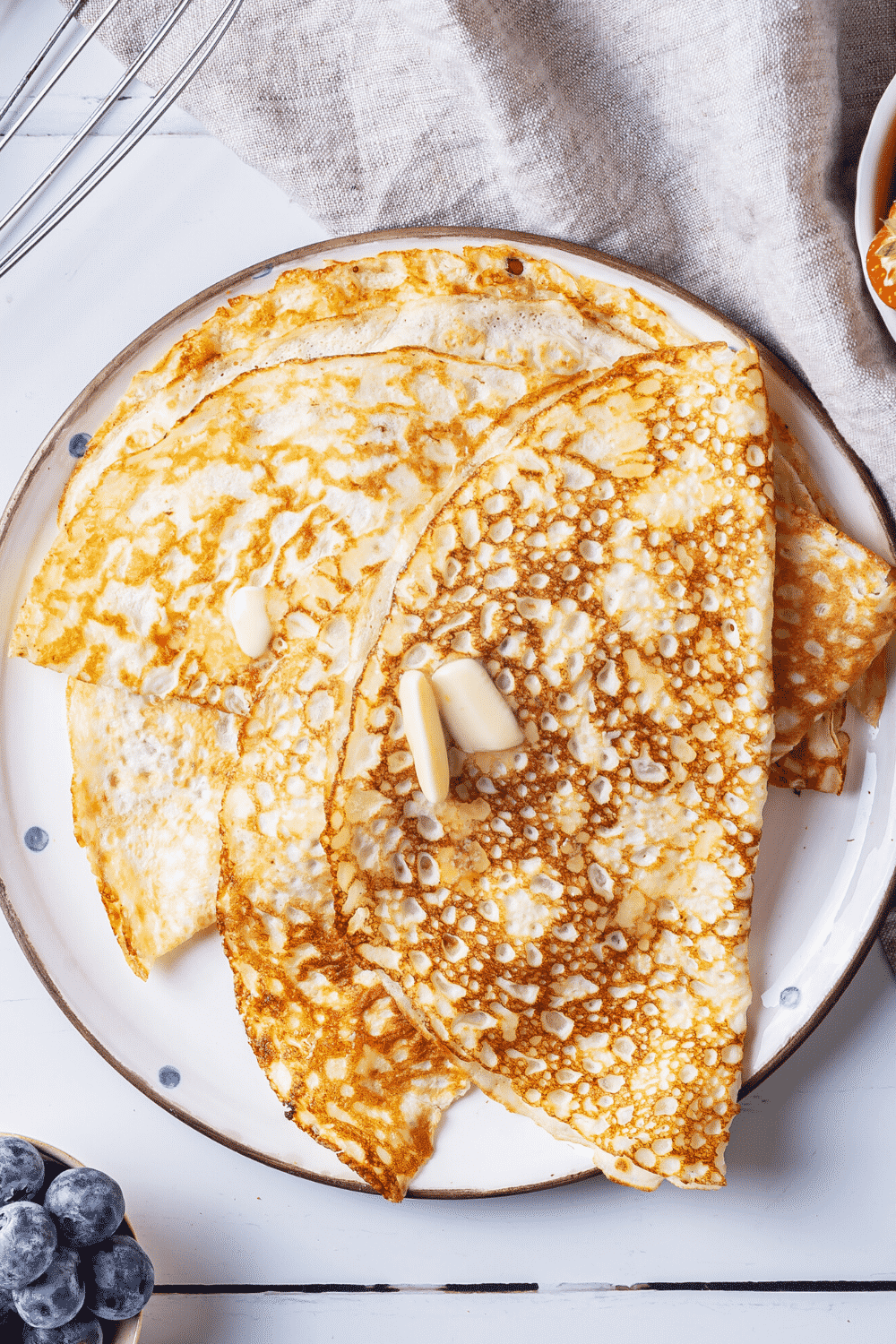 A white plate with a few crepes overlapping one another on it.