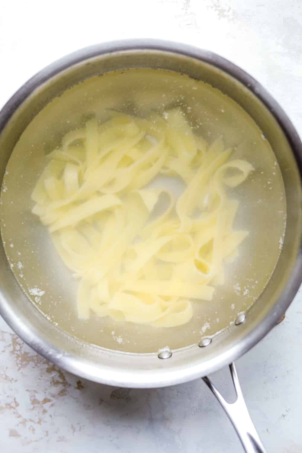 Pasta noodles in a pot of water.