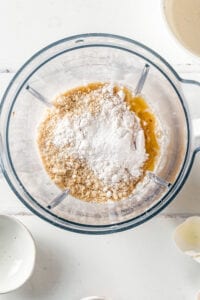 Keto waffle ingredients in a blender and a white counter.