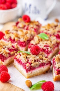 A raspberry cheesecake bar with some squares behind it.
