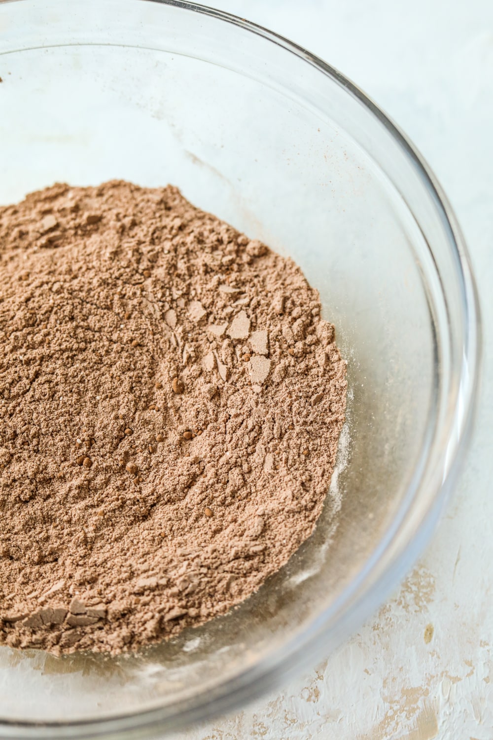 Dry ingredients mixed together for a chocolate mug cake in a glass bowl.