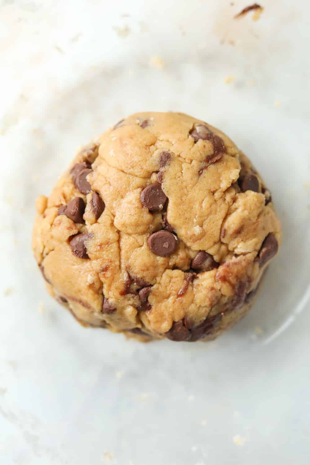 A ball of cookie dough in a clear bowl.