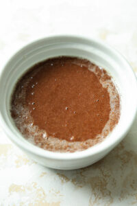 Chocolate cake batter in a white mug.