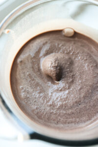 A chocolate smoothie inside of a blender.