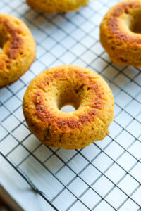 A drying rack filled with pumpkin spice donuts.