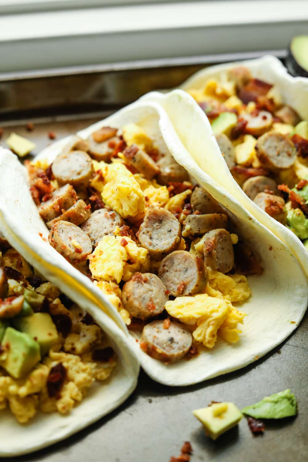 An egg white tortilla filled with sausage, eggs, and bacon.