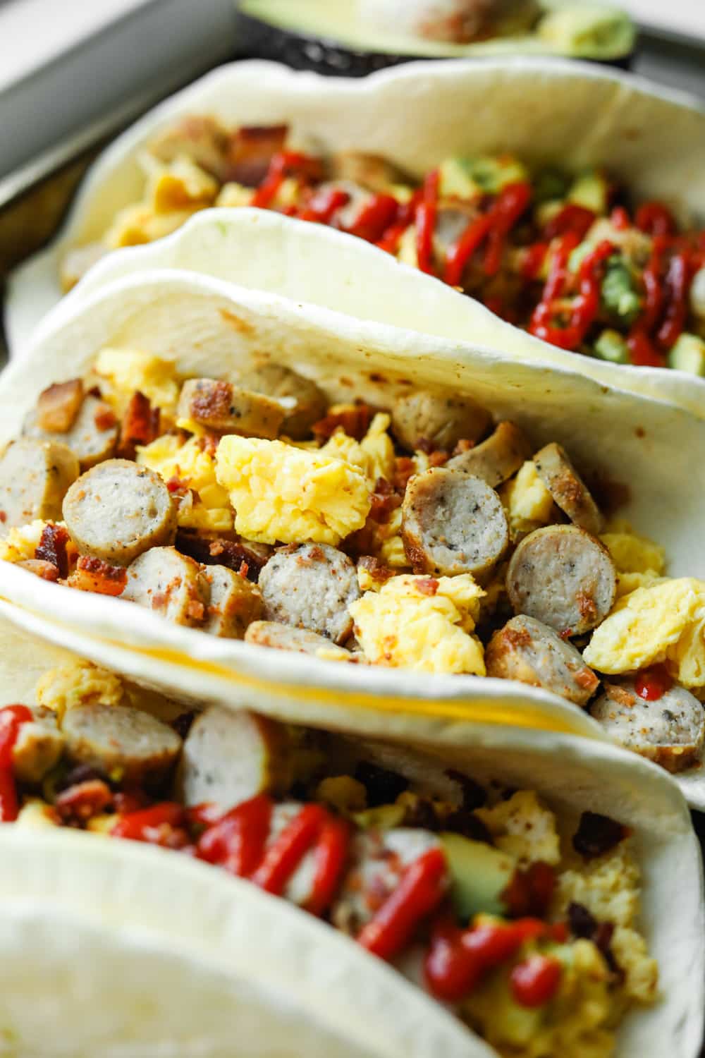 Open-faced breakfast burritos on a baking sheet