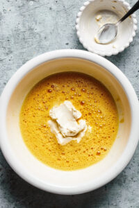 A white bowl filled with what ingredients and cream cheese for cream cheese pancakes.