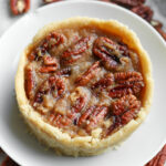 A pecan pie on a white plate.