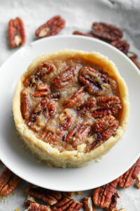 A pecan pie on a white plate.