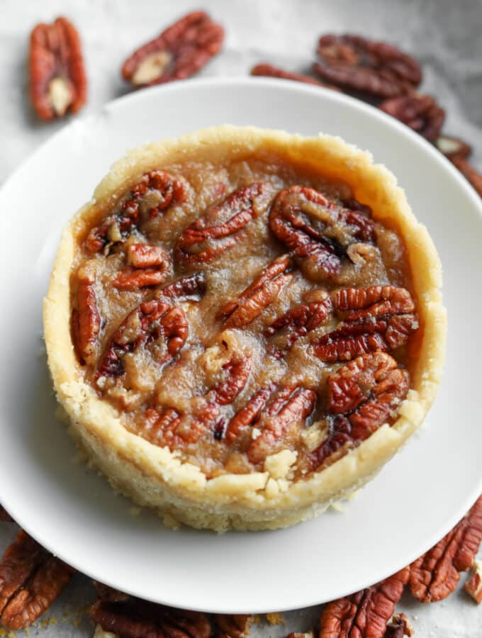 A pecan pie on a white plate.