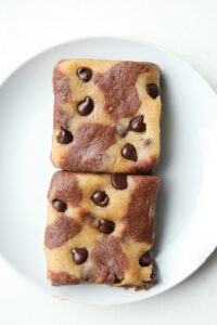 Two brookies that are unbaked on a white plate.