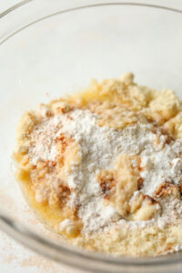 Flour, almond flour, vanilla extract, and melted butter in a glass bowl.