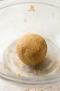 A ball of dough in a glass bowl.