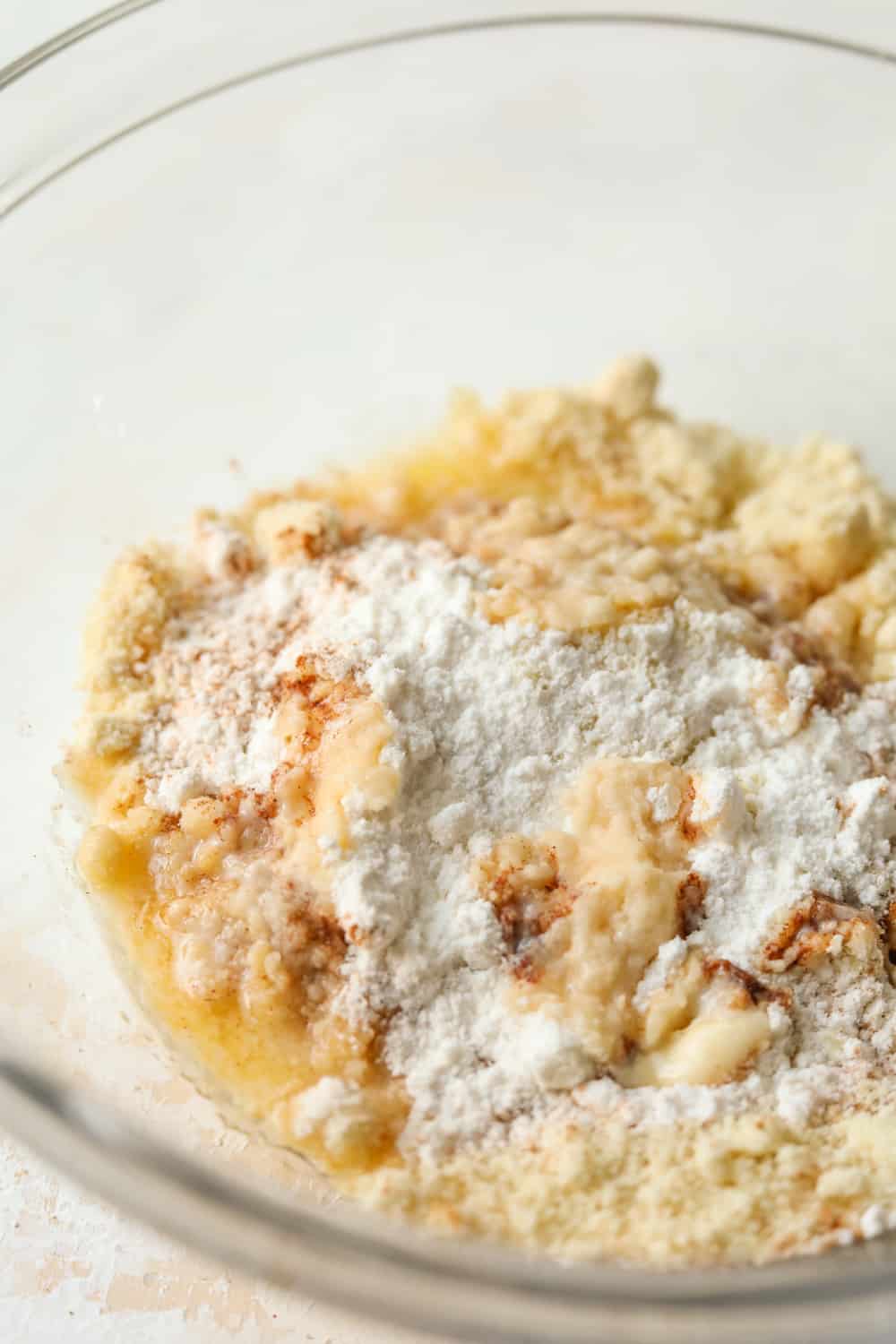 A glass dish filled with dry ingredients and melted butter.