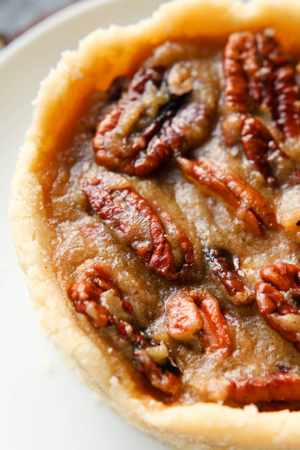 Half of a pecan pie on a white plate.