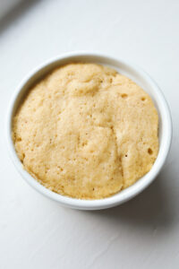 An apple spice cake inside of a white ramekin.