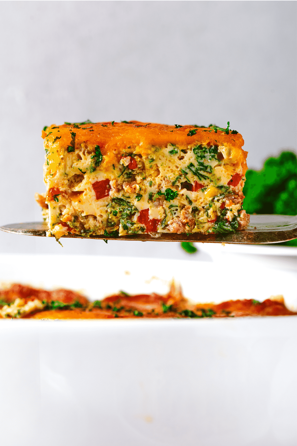 A serving spatula holding a piece of a breakfast casserole.