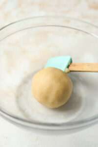 A ball of dough in a clear bowl.