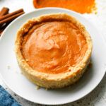 Pumpkin pie on a white plate. There's a blue napkin next to the plate.