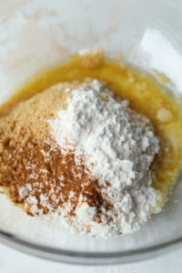 A mix of wet and dry ingredients in a glass bowl.