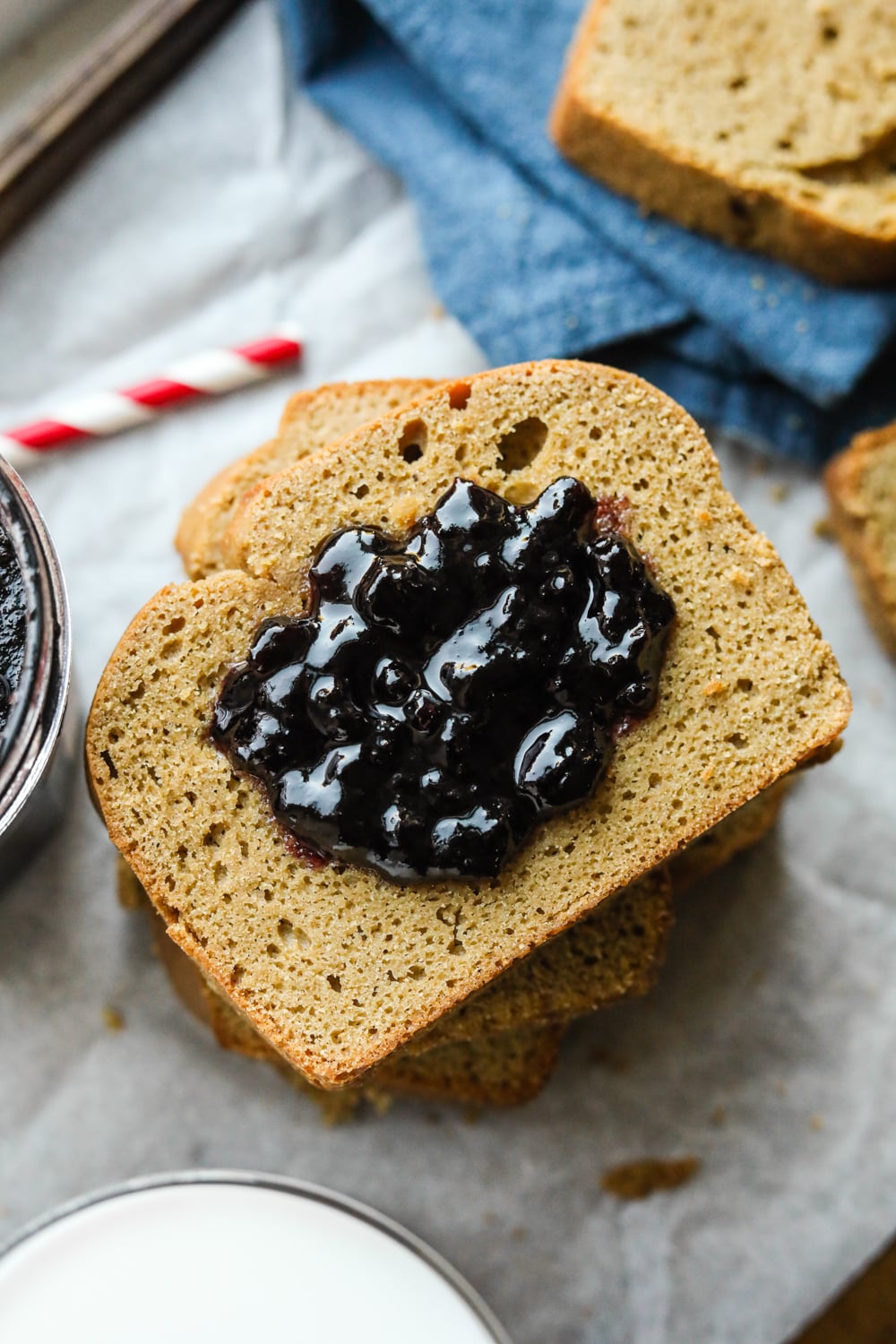 A slice of nut butter bread covered in grape jelly.