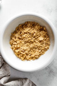 A white bowl with almond flour pie crust ingredients mixed together.