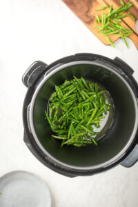 An instant pot filled with green beans.