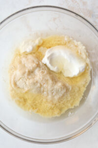 A glass bowl filled with almond flour, egg whites, and sour cream.