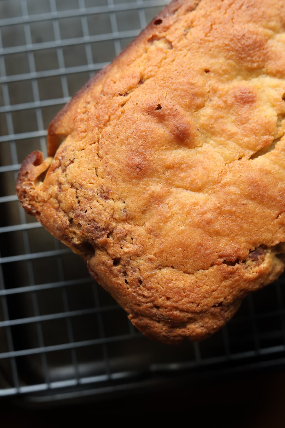 Cinnamon swirl bread on a drying rack. Only about half of the bread is shown.