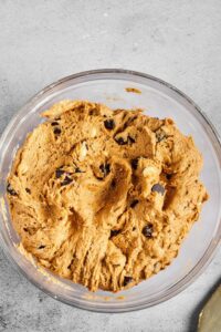 A glass bowl filled with chocolate chip cookie dough.