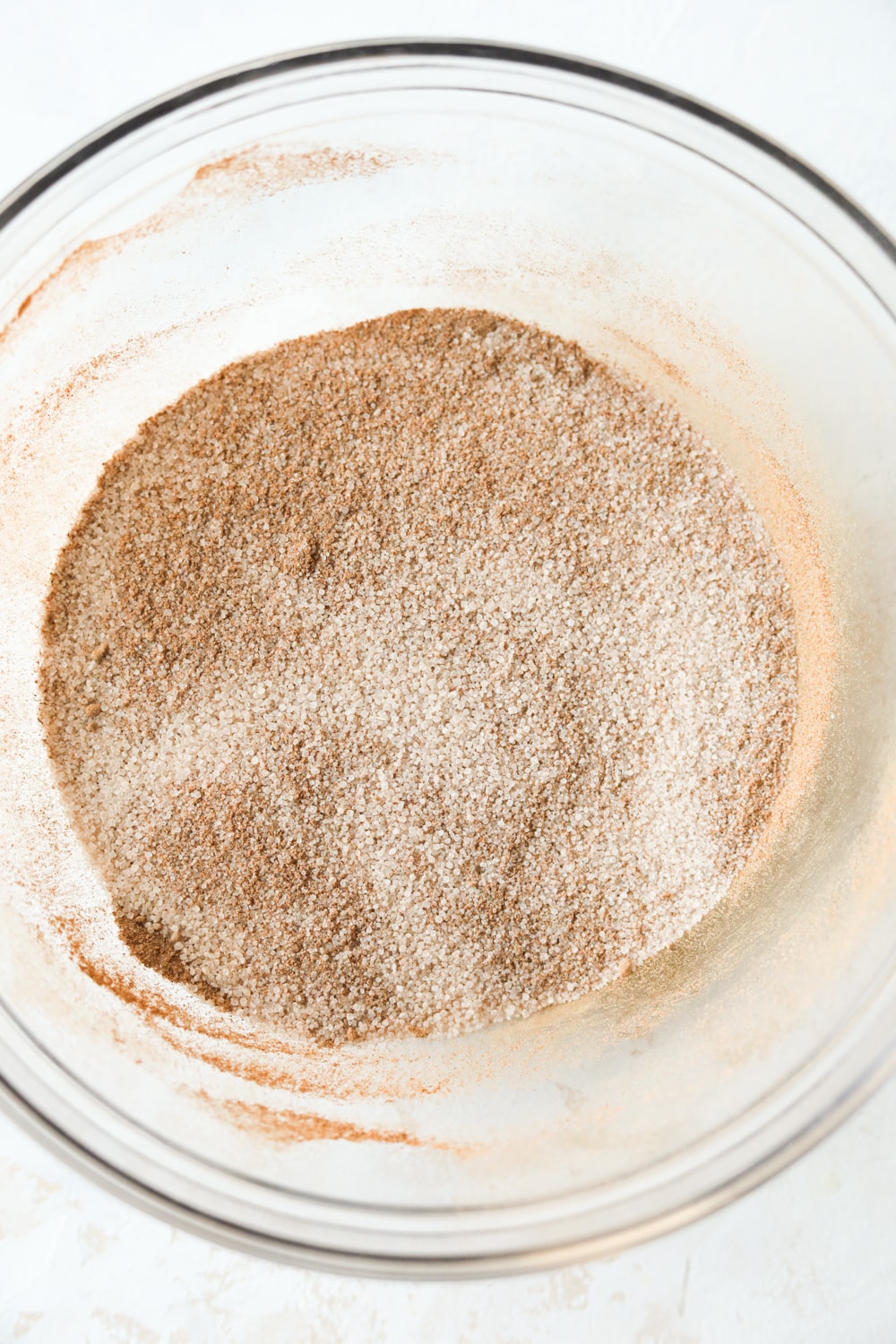 A glass bowl filled with cinnamon and a sugar substitute.