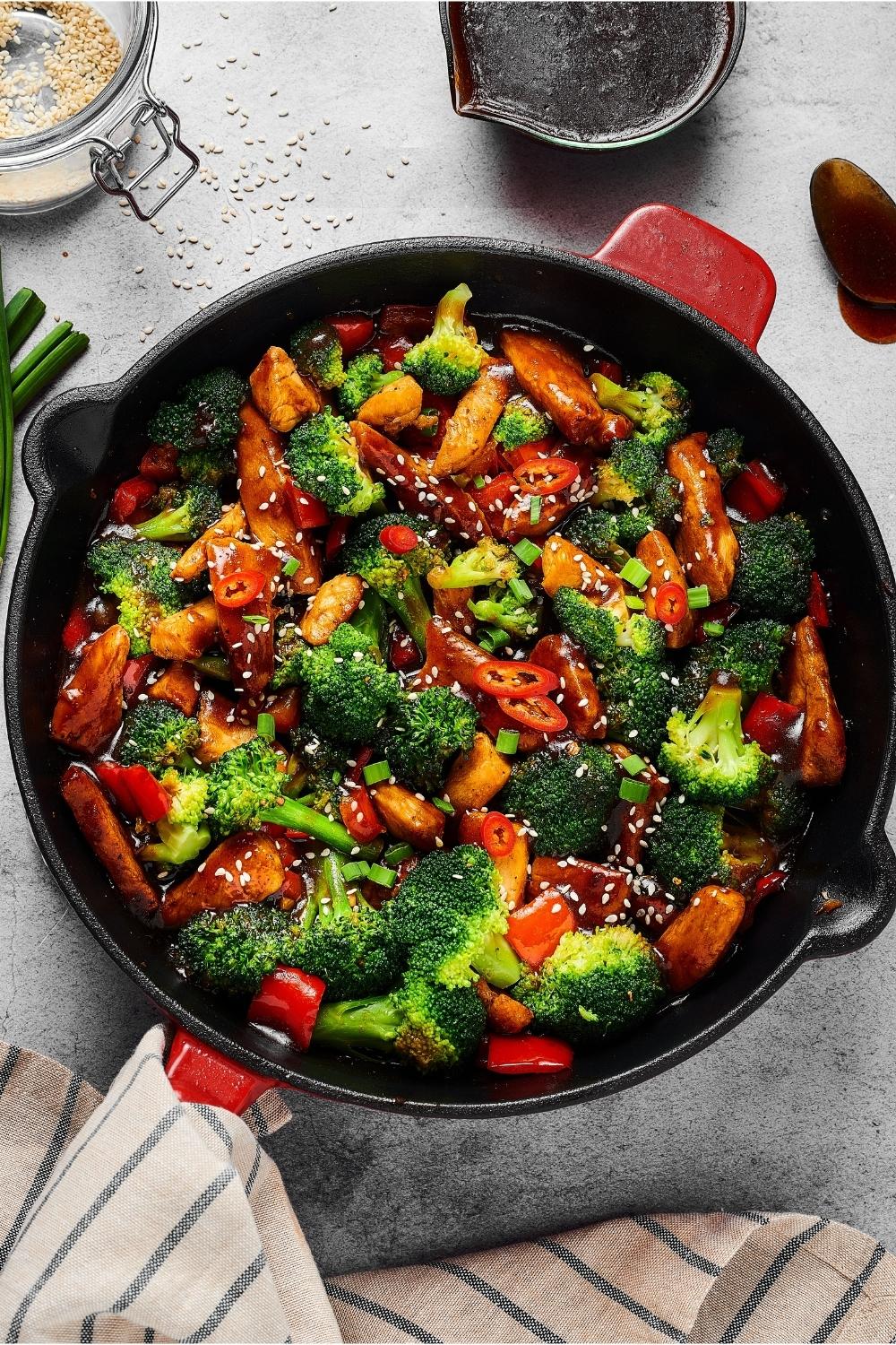 A cast iron pan filled with chicken stir fry.