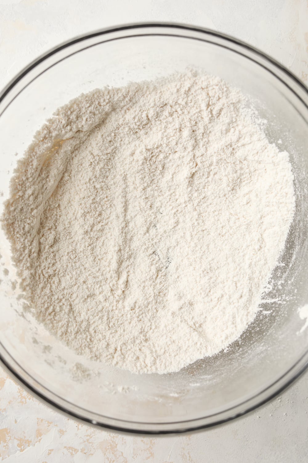 A glass bowl filled with dry ingredients.