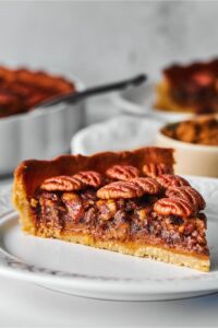 A slice of pecan pie on a white plate.