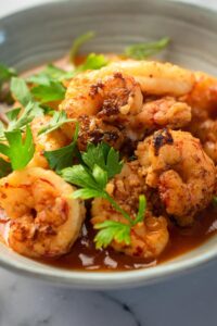 A bunch of shrimp in part of a gray bowl.