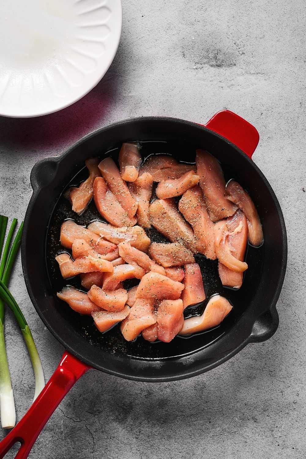 A skillet filled with sliced pieces of chicken.