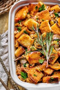 Part of a white casserole dish filled with stuffing.