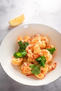 Shrimp in a white bowl on top of the gray counter.